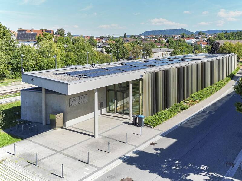 Das Gebäude der Bücherei im Hintergrund die Bahngleise